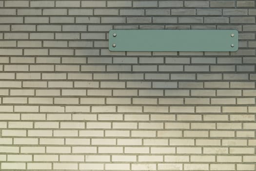 An empty sign on a new brick wall.  Fill in some text in the sign yourself.