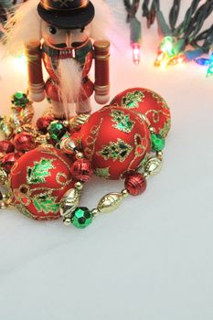 Red, green and gold Christmas decorations with lights in the background.