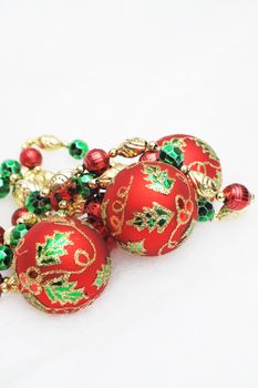 Red, green and gold Christmas decorations on a light background.
