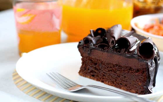 sliced chocolate cake served in white plate