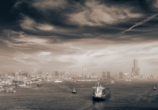 Cityscape of boats in port and city skyline in Kaohsiung, Taiwan.