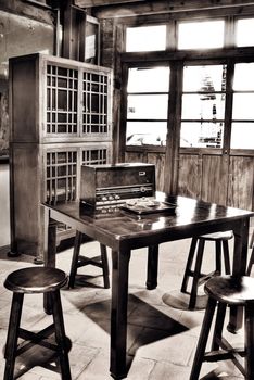 Asian old house interior with circle wooden chair and antique radio on desk.