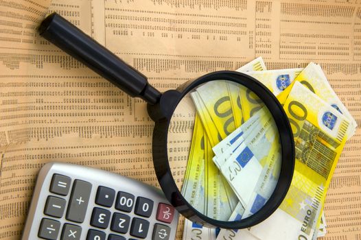 Closeup of euros, calculator and lens and background of newspaper with stock rate