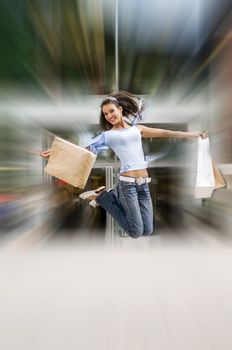 beautiful brunette jumping with her shopping bags after a hard day in center