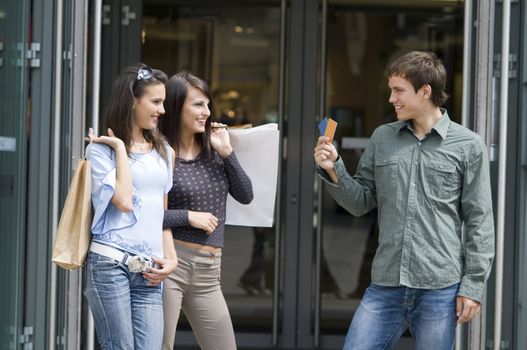 men trying to pick up two girls showing them his credit cards in shopping time