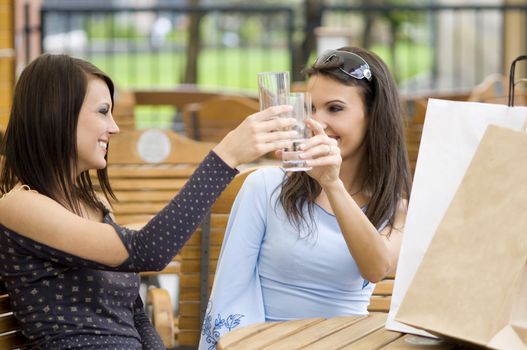 two girls sitting and celebrating drinking the good shopping just made