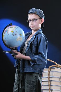 The boy of ten years in glasses gets on the hip student's globe