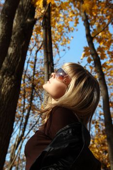 beautiful young girl looking up on autumn background