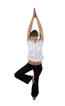 woman practicing yoga on one leg in studio