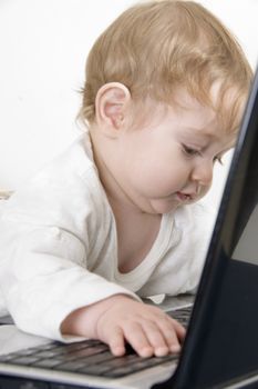 curious baby playing with laptop