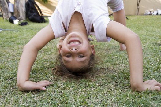 cute girl doing a bridge in the garden