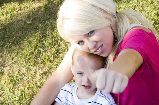mother holding child and with thumbs up hand gesture