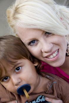 boy with pacifier posing with his mother