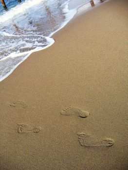 Human footprints leading into the sea