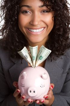 Smiling black woman holding piggy bank