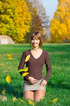 The young girl in autumn park during a leaf fall