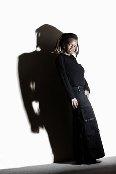 African American woman with dreadlocks against a white wall