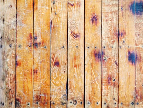 A wall covered with old scratched wooned boards