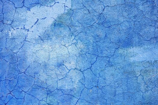 The blue wall are covered with cracked plaster