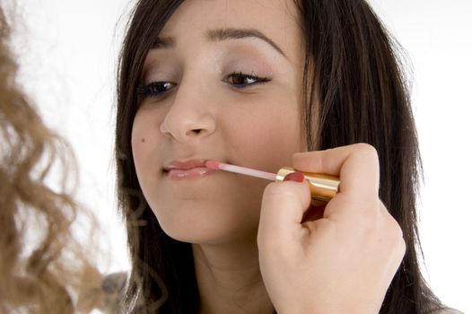  beautiful teen getting applied lipstick with brush on  an isolated white background 