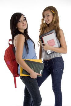 school girls standing together holding books on  an isolated white background 