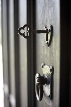 an open antique door with key in the lock