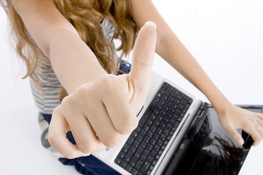 girl with laptop showing her thumb on  an isolated white background 