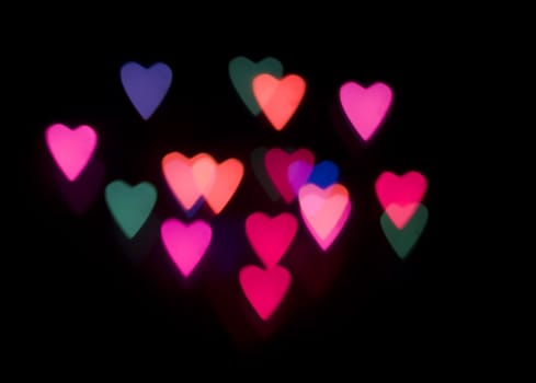 multi coloured heart shaped glowing lights on a black backdrop