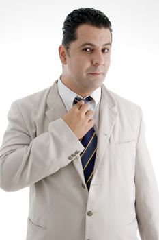 businessman adjusting his tie and looking to camera on  an isolated white background 