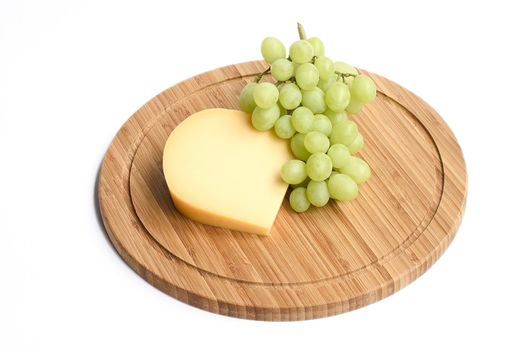 green grapes and cheese on a wooden board