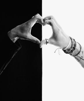 Close up of black and white hands making a heart