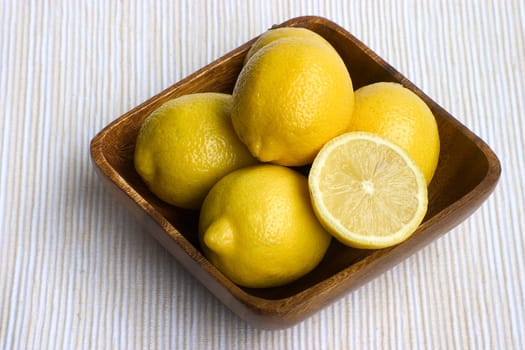 lemons arranged in a brown bowl