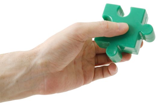 The hand holding a green piece puzzle on a white background