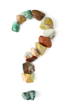 A question mark formed of polished stones of various colors.