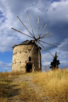 An old windmill in Ormylia (Halkidiki) on a cloudy day in July.