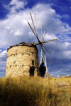 An old windmill in Ormylia (Halkidiki) on a cloudy day in July.