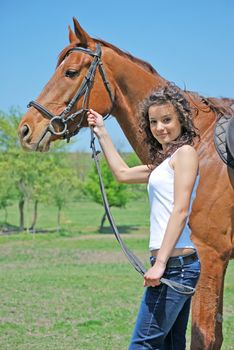 young and attractive woman riding brown horse