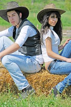 young couple in love sitting on a hay bale