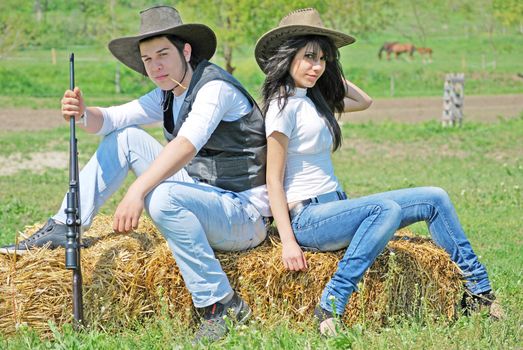 young couple sitting on hay bale