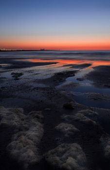 Coloured sky from volcanodust in the air after the sunset at the beach -  vertical image