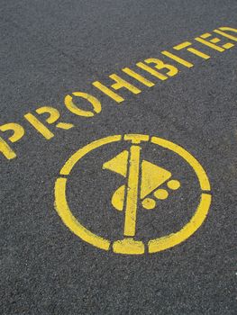 yellow painted pavement sign prohibiting inline skating