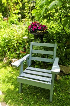 Wooden chair in a secluded corner of lush green garden