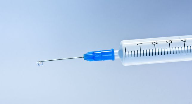 Medical Syringe with blue drop, isolated