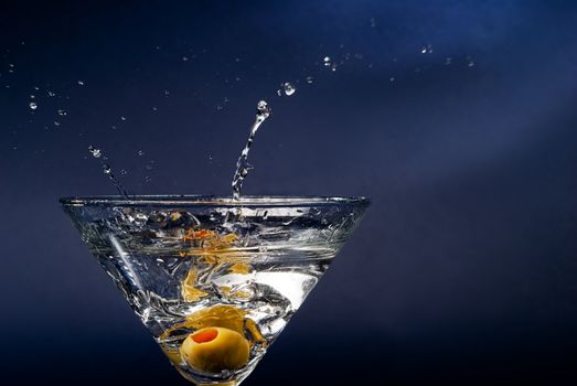 Splashing olive on cocktail glass