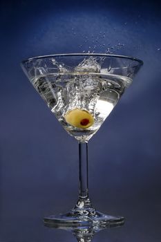 Ready cocktail with an olive splashing