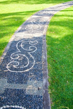 Decorated footpath in a botanical garden from small stones.