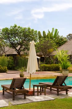 Two chairs and umbrella by the swimming pool