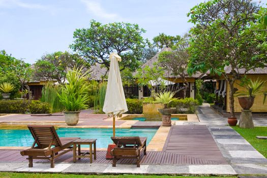 Two chairs and umbrella by the swimming pool