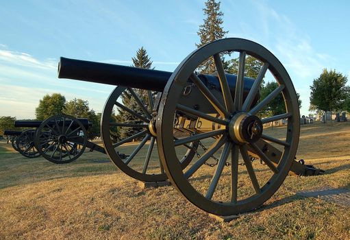 Old cannons in front of an old cemetery