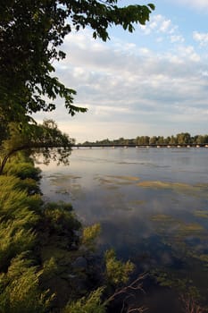 A beutiful river in summer with a bridge in the distance